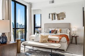 Dallas apartment for rent - a bedroom with a bed and a large window
