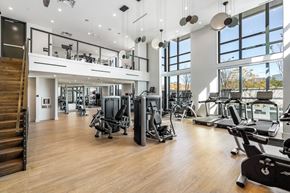 Dallas apartment for rent - a gym with cardio equipment and large windows