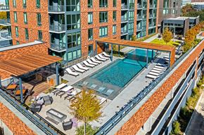 Dallas apartment for rent - an aerial view of a swimming pool in front of an apartment building