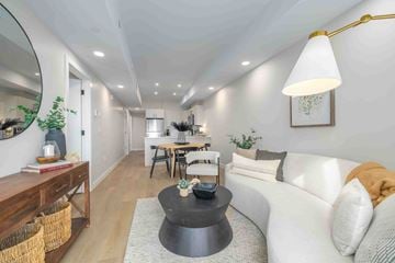 Winnipeg apartment for rent - A modern living room with a white sofa and a black coffee table.