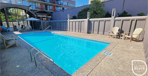 Vancouver apartment for rent - A swimming pool surrounded by a concrete floor and a metal fence.