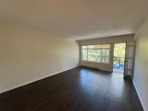 Victoria apartment for rent - A room with wooden floors and a window with blinds.