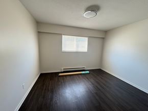 Victoria apartment for rent - A room with a window and a wooden floor.