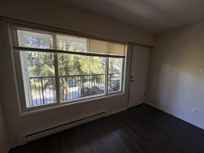 Victoria apartment for rent - A room with a sliding glass door leading to a balcony.