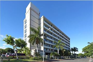 Waipahu apartment for rent - a large white building with palm trees in front of it