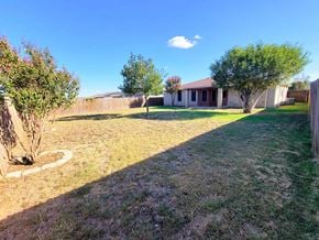 Killeen house for rent - a backyard with a house and a yard with grass and trees