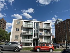 Calgary apartment for rent - an apartment building with cars parked in front of it