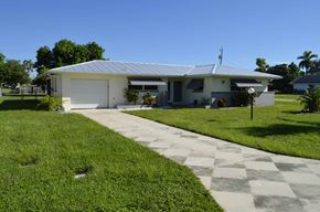 Cape Coral house for rent - a house with a driveway and a lawn