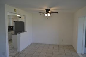 Cape Coral house for rent - an empty living room with a ceiling fan and a tiled floor