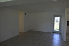 Cape Coral house for rent - an empty living room with a tile floor and a door