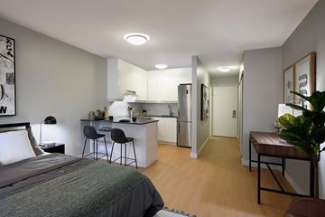 Ottawa apartment for rent - A bedroom with a bed, desk, and kitchenette.