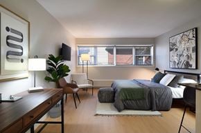Ottawa apartment for rent - A modern bedroom with a bed, chair, and a desk.