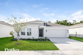 Winter Haven house for rent - a white house with a lawn and a driveway