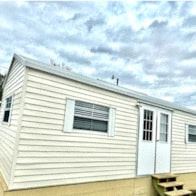 Lakeland apartment for rent - a small white house with a blue sky and clouds