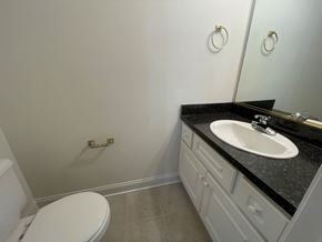 Wilson apartment for rent - A bathroom with a white toilet and a black counter top.