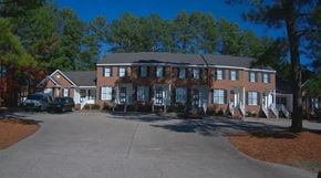 Wilson apartment for rent - A large building with a parking lot in front of it.