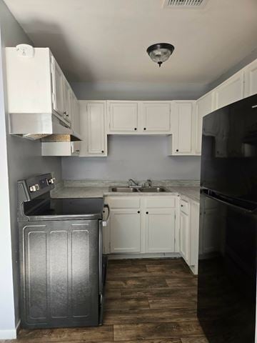 Hattiesburg apartment for rent - A kitchen with white cabinets and a black refrigerator.