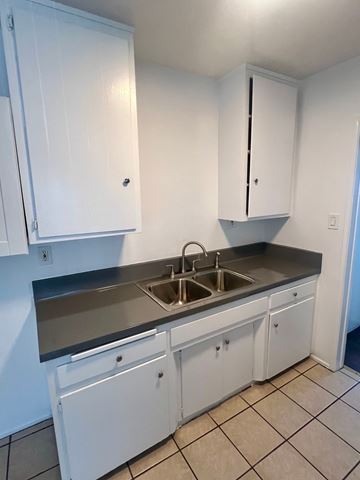 Long Beach apartment for rent - A kitchen with white cabinets and a sink.