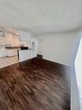 Long Beach apartment for rent - A kitchen with white cabinets and a black microwave.