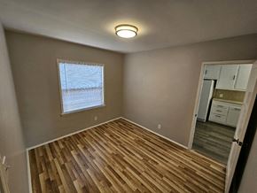 Pico Rivera apartment for rent - an empty living room with a hard wood floor and a window