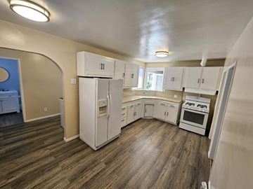 Pico Rivera apartment for rent - a kitchen with white cabinets and a stove and a refrigerator