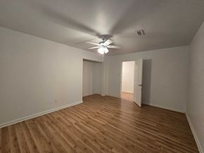 Gary house for rent - an empty living room with a ceiling fan and wood floors