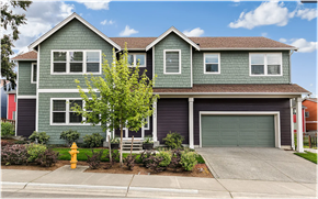 Seattle house for rent - A green two-story house with a garage and a tree in front.