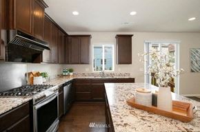 Seattle house for rent - A kitchen with brown cabinets and granite countertops.