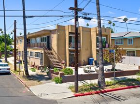 Los Angeles apartment for rent - A street view of a residential area with a car parked on the side of the road.