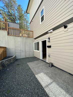 Langford apartment for rent - A concrete patio area in front of a house with a door and a window.