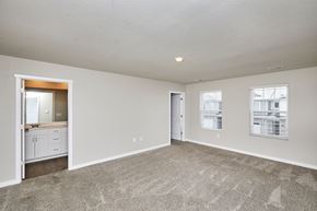 Waukee apartment for rent - A spacious empty room with a carpeted floor and a doorway leading to another room.