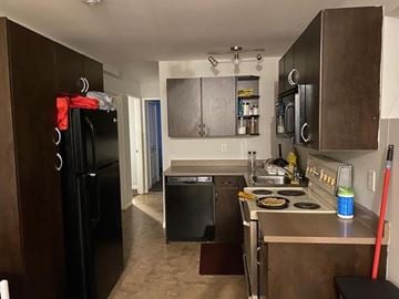 Victoria apartment for rent - A kitchen with a black fridge and a black dishwasher.