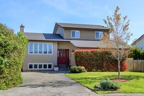 Victoria apartment for rent - A house with a red door and a red bush in front.