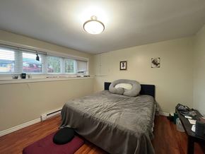 Victoria apartment for rent - A bedroom with a bed, a desk, and a window with blinds.
