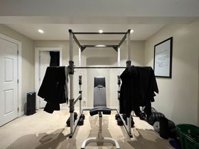 Victoria apartment for rent - A home gym with a squat rack, bench, and weights.