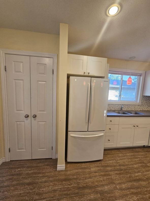 London apartment for rent - A white refrigerator in a kitchen with brown flooring.