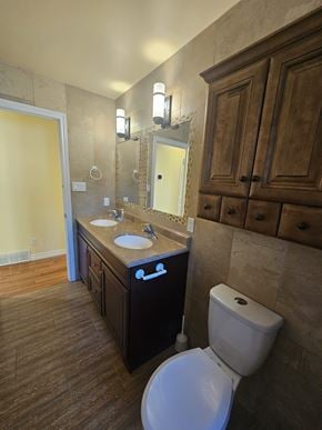 London apartment for rent - A bathroom with a toilet, sink, and mirror.