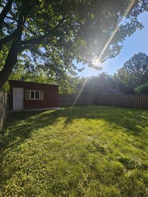 London apartment for rent - A small red shed sits in a grassy backyard.