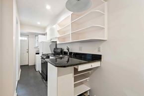 Washington apartment for rent - A modern kitchen with a black countertop and white cabinets.