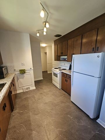 London apartment for rent - A kitchen with a white refrigerator and wooden cabinets.