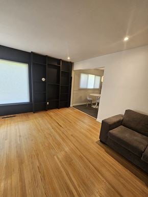 London apartment for rent - A room with a wooden floor and a brown couch.