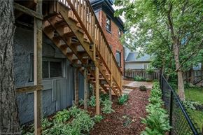 Woodstock apartment for rent - A wooden staircase leads up to a building.