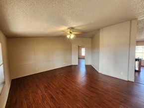 Shawnee house for rent - A room with wooden floors and a ceiling fan.