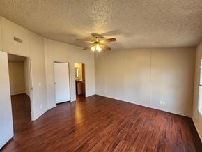 Shawnee house for rent - A room with wooden floors and a ceiling fan.