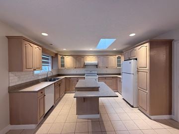 Victoria apartment for rent - A kitchen with wooden cabinets and a white refrigerator.