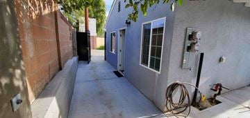 Los Angeles house for rent - the side of a house with a long sidewalk and a door
