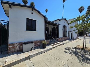 Los Angeles house for rent - the front of a white building with a black window and a sidewalk