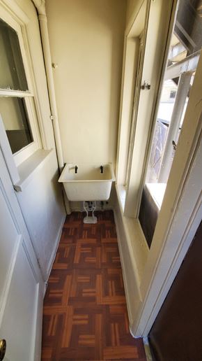 Los Angeles apartment for rent - A small white toilet in a narrow space between two walls.