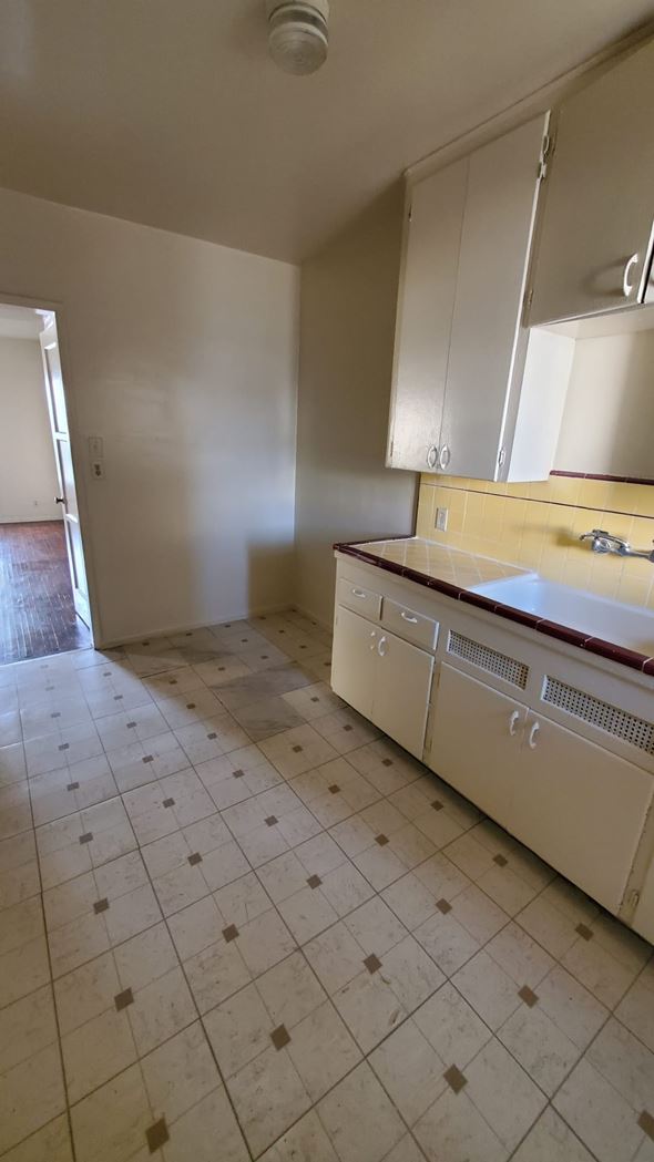 Los Angeles apartment for rent - A kitchen with white cabinets and a tiled floor.