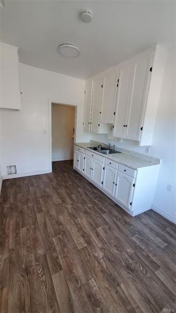 Los Angeles apartment for rent - A kitchen with white cabinets and a wooden floor.